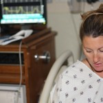 day73_sm Sharon with her monitor in the background showing the contractions as rhythmic peaks