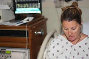 Sharon with her monitor in the background showing the contractions as rhythmic peaks